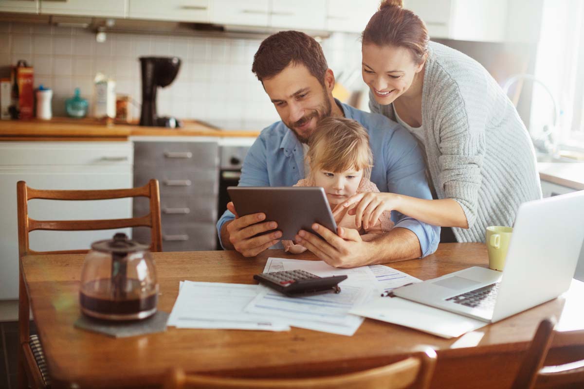 Young,Family,Using,A,Digital,Tablet,In,The,Morning