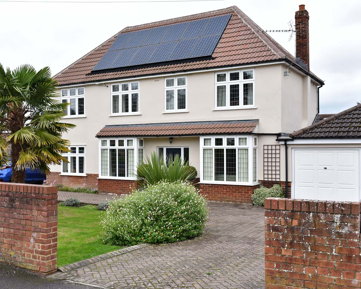 Front of a large family home with solar panels in an Irish neighbourhood, covered by home insurance.