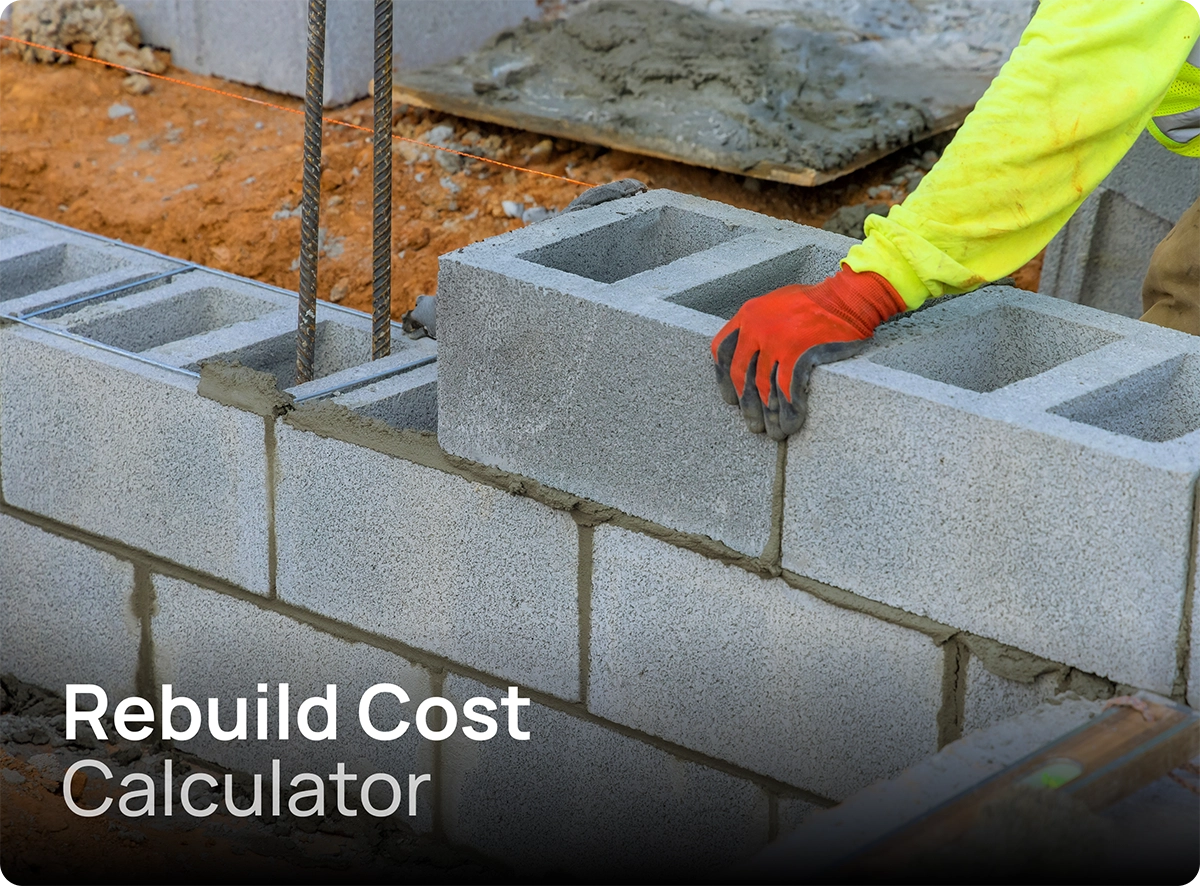 house-rebuild-cost-calculation Builder carefully rebuilding a house with concrete blocks and cement